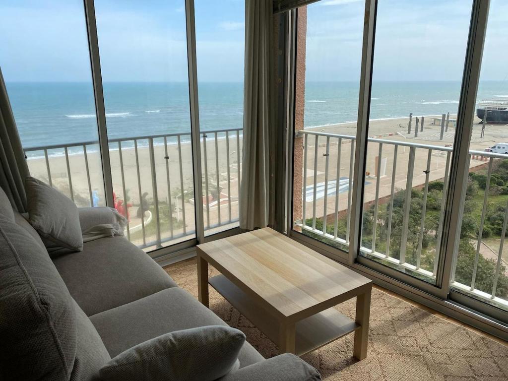 - un salon avec un canapé et une vue sur la plage dans l'établissement Appartement Vue Mer, au Barcarès