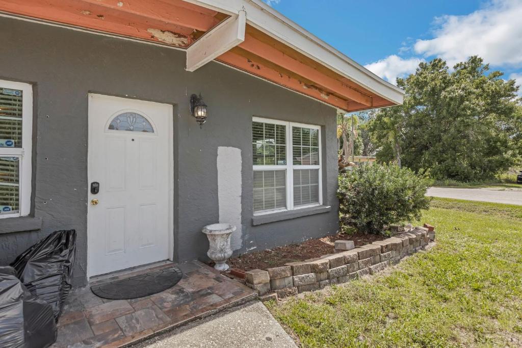 a gray house with a white door and a yard at Amazing 'Hot Tub' Home Minutes To Hospitals & Beaches in Palmetto
