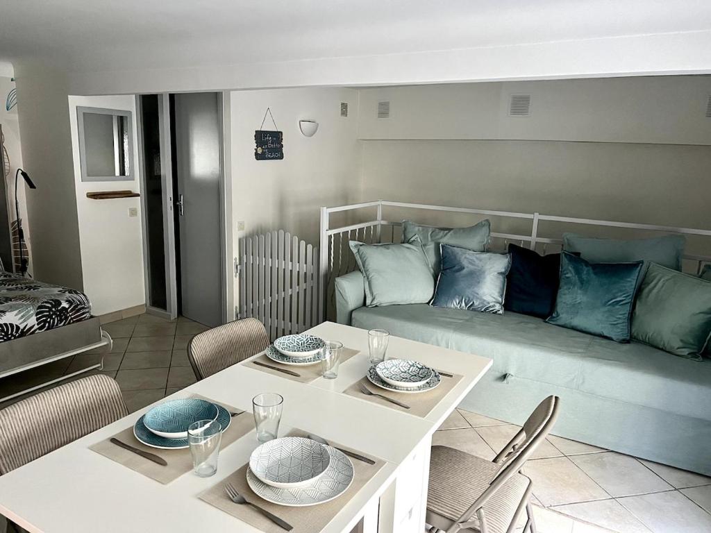 un salon avec une table et un canapé dans l'établissement Cozy duplex near the beach with with Aircon, à Nice