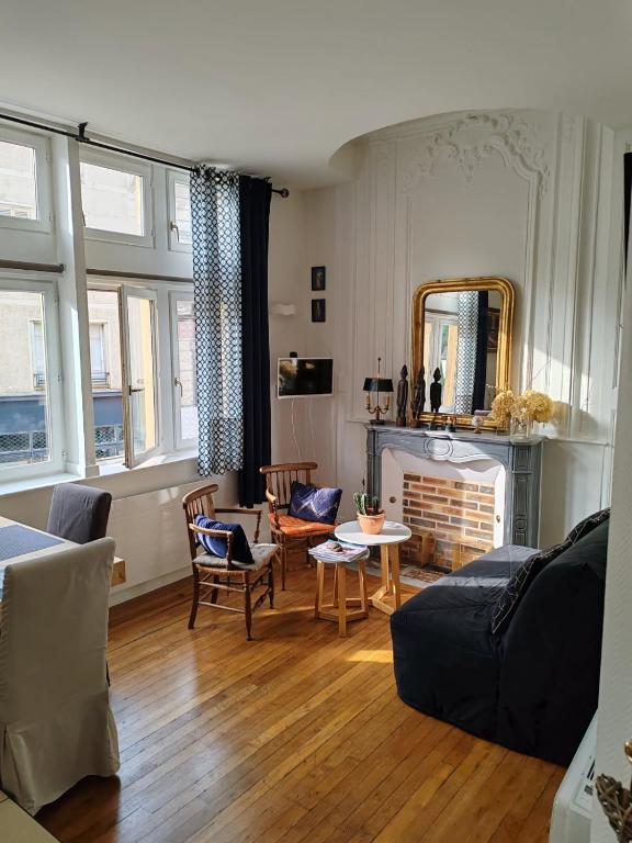 un salon avec un canapé et une cheminée dans l'établissement Le Jean Jaurès, à Troyes