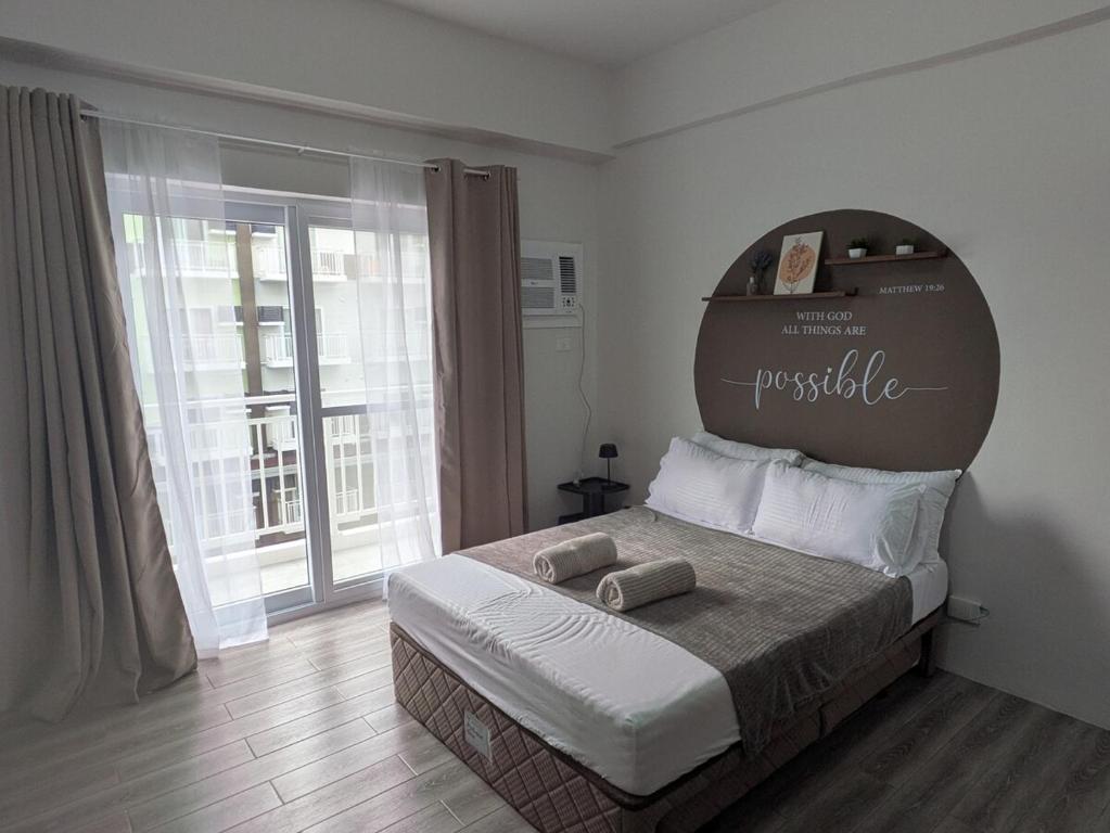 a bedroom with a large bed with two towels on it at Cebu Airport budget Luxury living Rest& Fly at Amani Grand Resort in Pusok