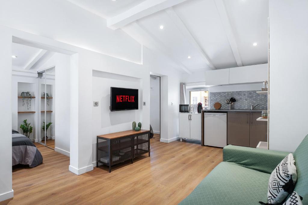 un salon avec un canapé et une horloge au mur dans l'établissement Nice Renting - 6B FRANCE - Massena beach design AC quiet center wifi, à Nice