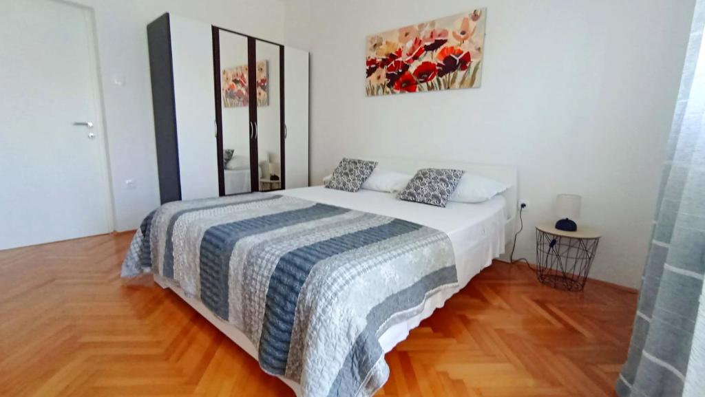 a bedroom with a bed with a blue and white blanket at Apartment Tea 2 in Okrug Donji