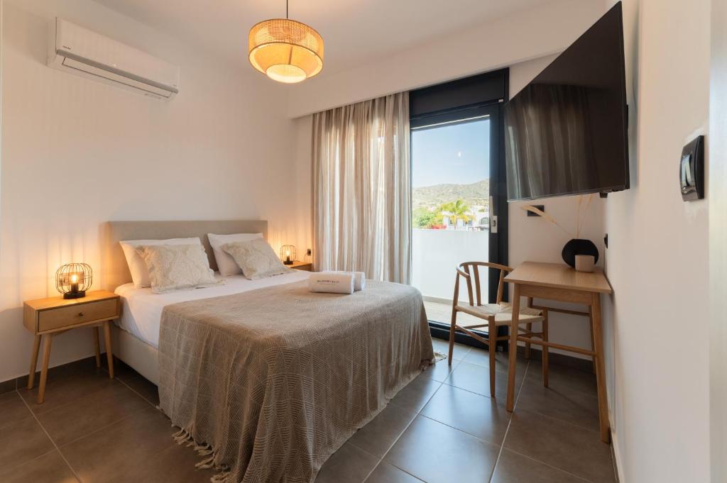 a bedroom with a bed and a table and a window at Prasonisi Villas in Kattavía