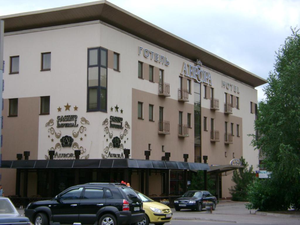 a hotel with cars parked in front of it at Optima Collection Aurora Kryvyi Rih in Kryvyi Rih