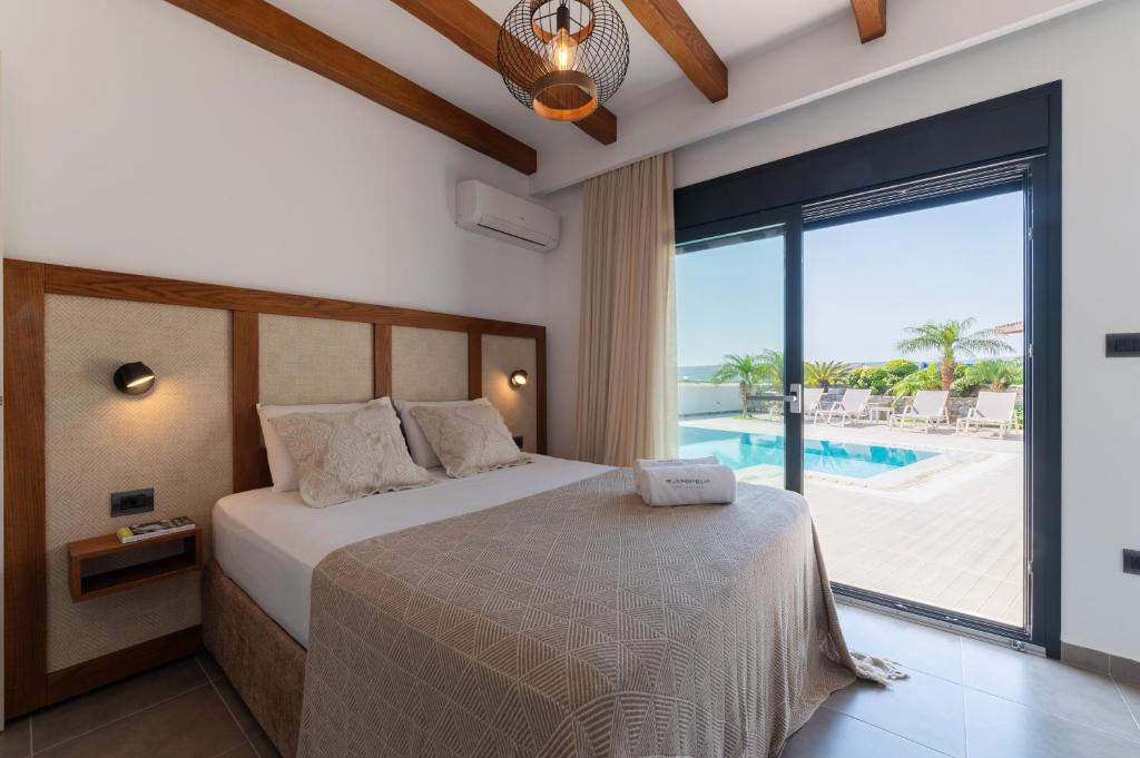 a bedroom with a bed with a view of a pool at Prasonisi Villas in Kattavía