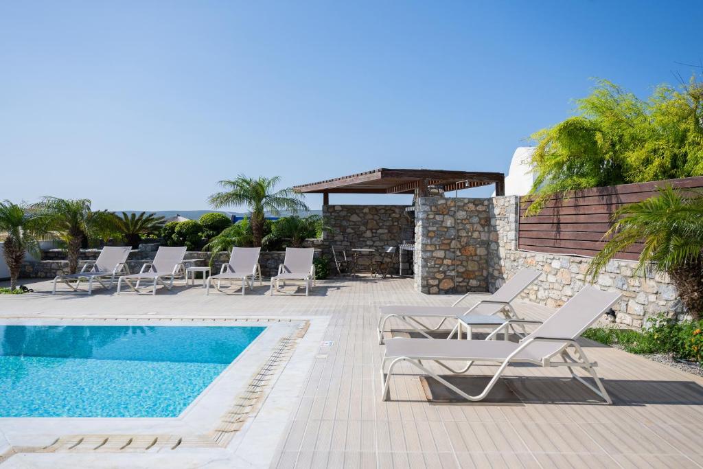 a villa with a swimming pool and lounge chairs at Prasonisi Villas in Kattavía