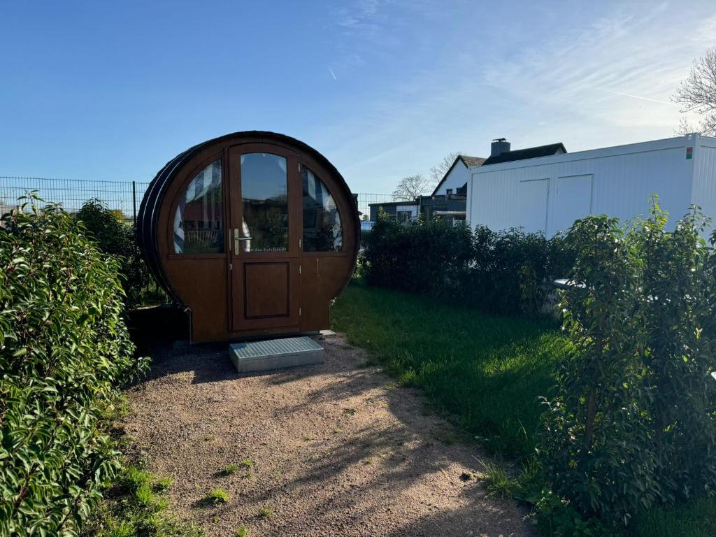 a wooden door in the middle of a yard at Schlaffass auf Stellplatz am Elbkrug 2 0 in Büttel