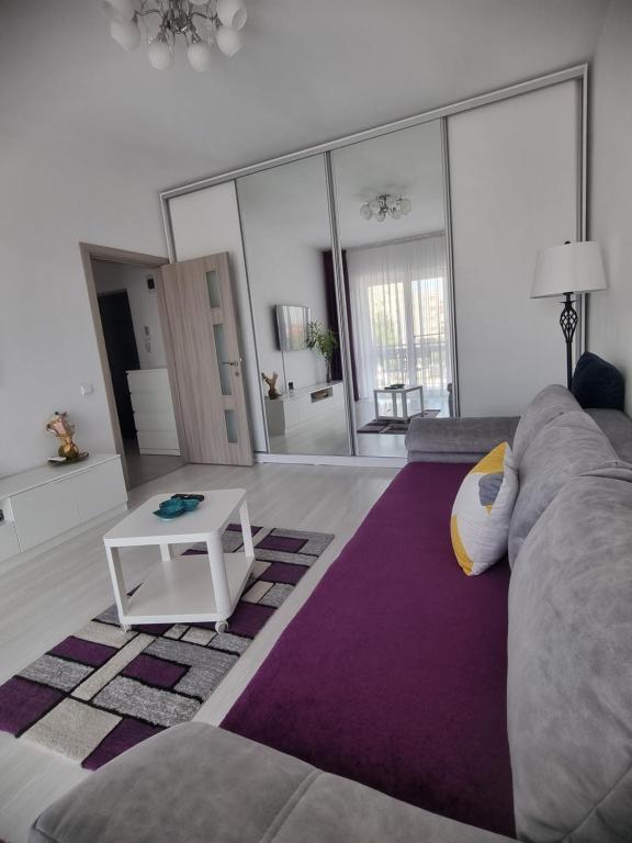 una sala de estar con un sofá y una mesa en ONE Apartment Militari, en Bucarest