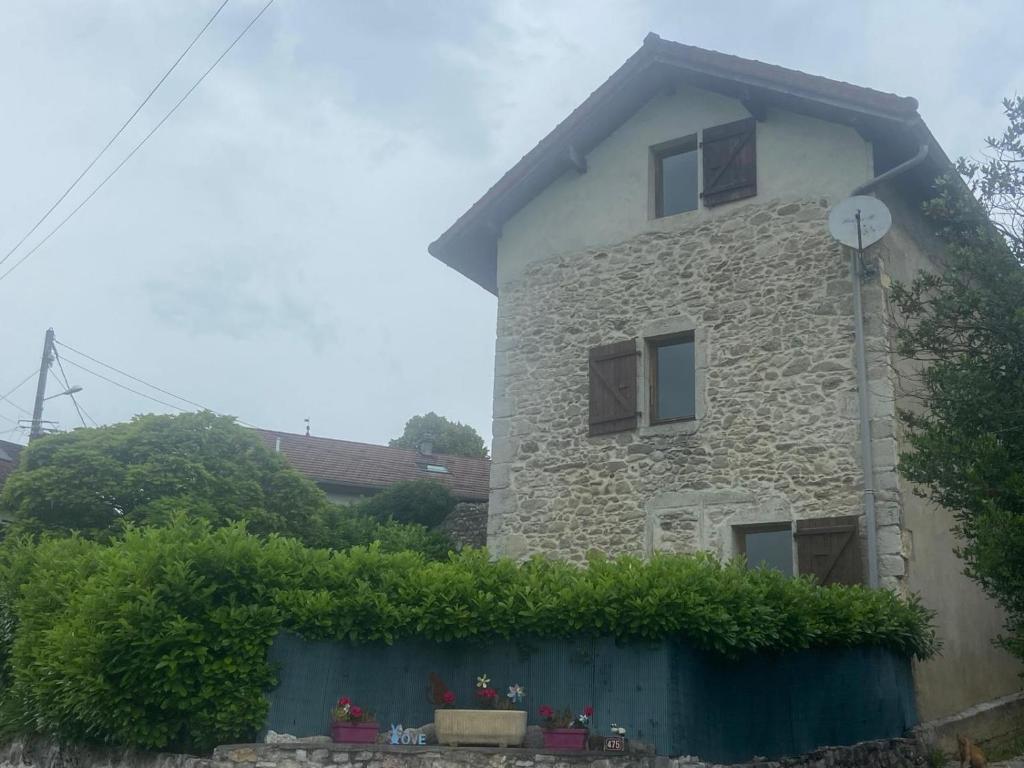 a stone building with windows and flowers in front of it at Charmante maison de village avec jardin, proche abbaye d'Hautecombe in Saint-Pierre-de-Curtille