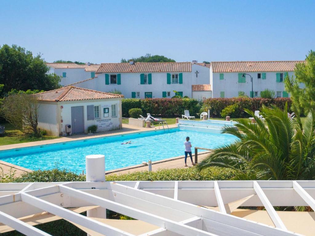 a person standing next to a swimming pool at Thalacap Île de Ré - Thalasso & Spa in Ars-en-Ré