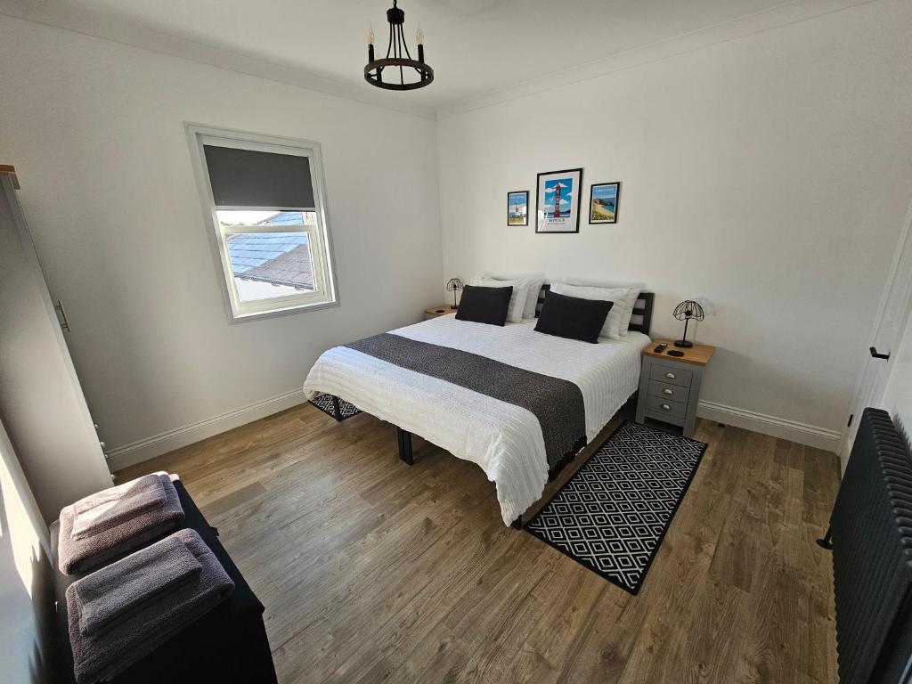 a bedroom with a bed and a chair and a window at The Nest in Weymouth in Weymouth