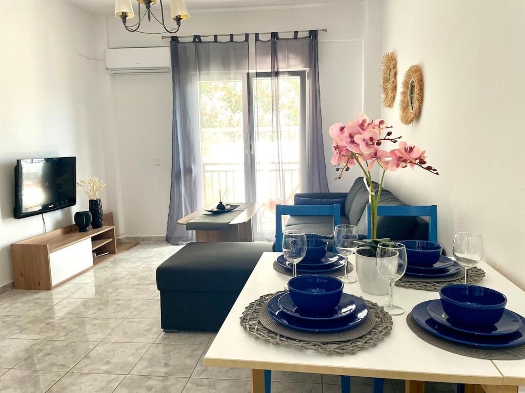 a living room with a table with blue dishes on it at Marias Apartment in Pefkohori