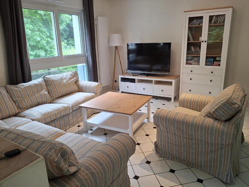 un salon avec deux canapés et une télévision dans l'établissement Maison à 5 minutes de la plage à pied, à Binic