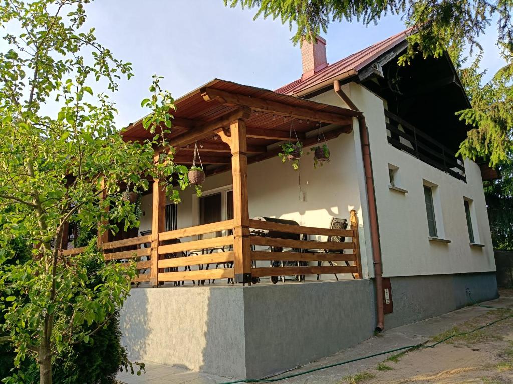 een huis met een veranda met een dak bij Dom Letniskowy in Wielen Zaobrzanski