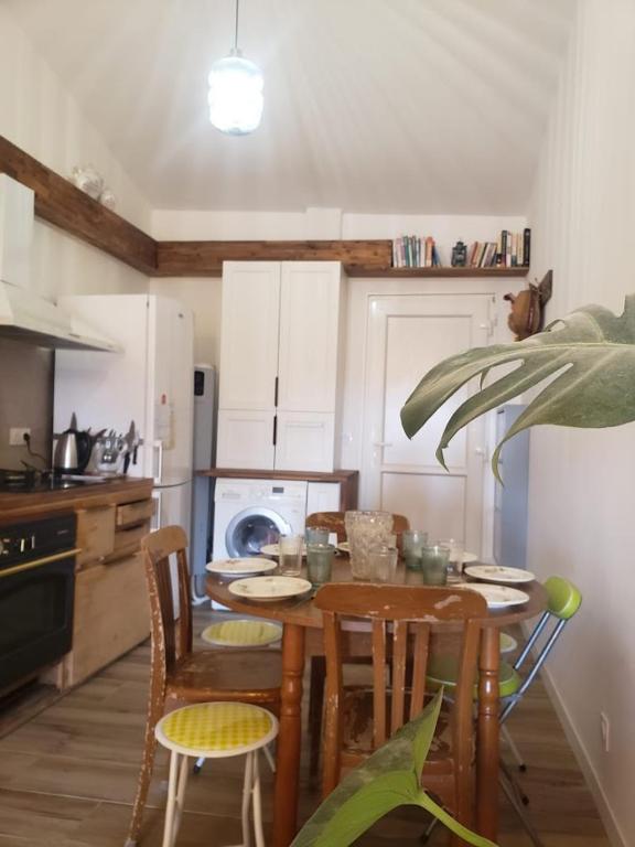 une cuisine avec une table en bois avec des chaises et un plateau de table dans l'établissement Le clocher de Castries, à Castries