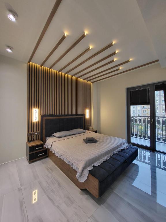a bedroom with a large bed and a large window at Luxury Residence in Mirabad Avenue in Toshkent-Passajir Bekati