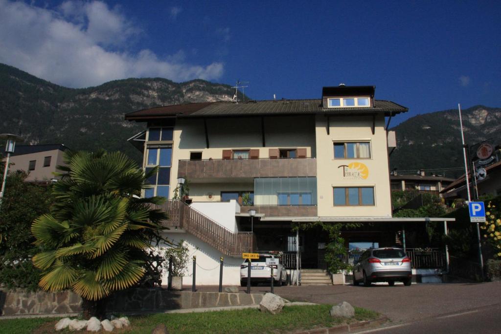 un gran edificio con un coche aparcado delante de él en Residence La Terrazza, en Caldaro