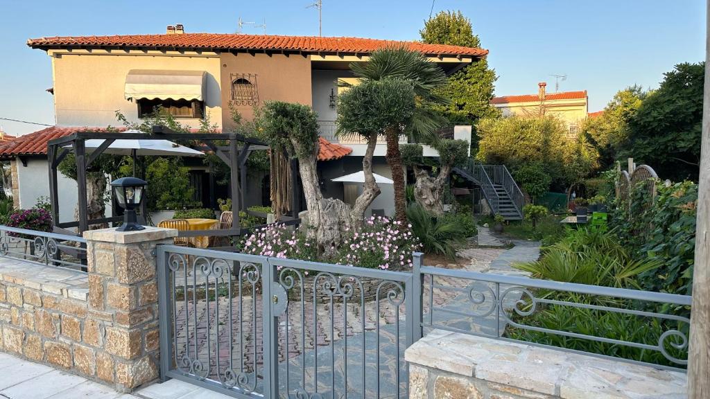 a fence in front of a house with flowers at Greek Mansion in Nea Moudania