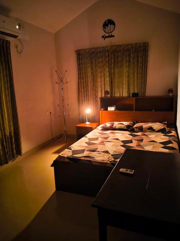 a bedroom with a bed and a table in it at Gripzy Serene Abode-Kazhakuttam in Trivandrum