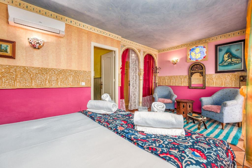 a living room with pink walls and chairs at La Casa Del Maestro in Estepona