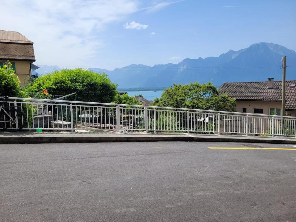 VeytauxStudio with a view of Lake Geneva的湖边街道旁的白色栅栏