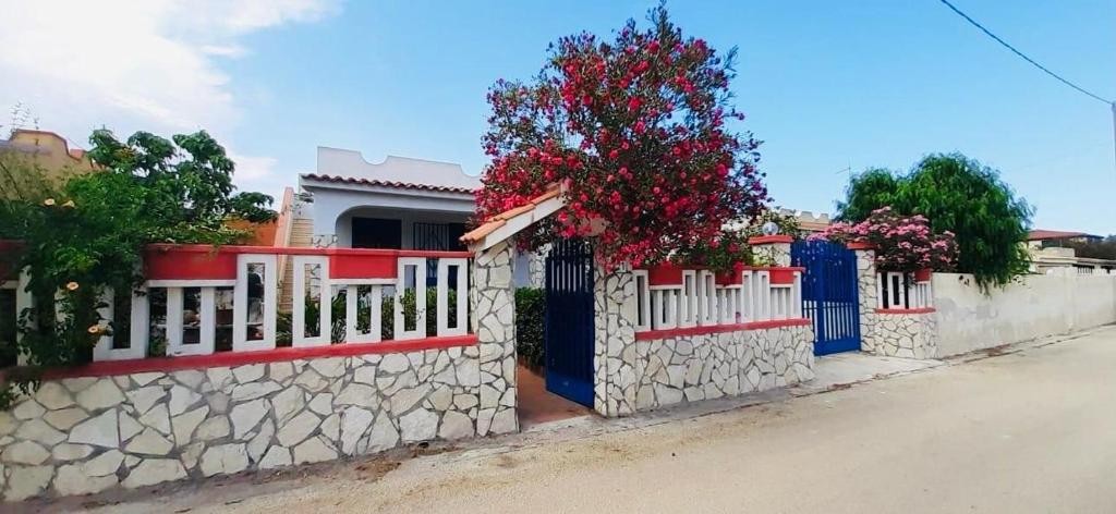 una staccionata bianca con fiori rossi su una strada di oasis home a Reitani