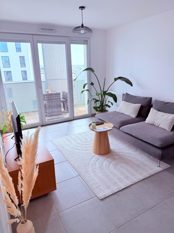 a living room with a couch and a table at L'Occitan T2 à 10 minutes du cœur de Toulouse Parking privé et Métro in Toulouse