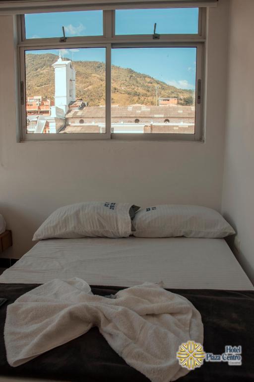 a bed in a room with a window at Hotel Plaza Centro Cocorná in Cocorná