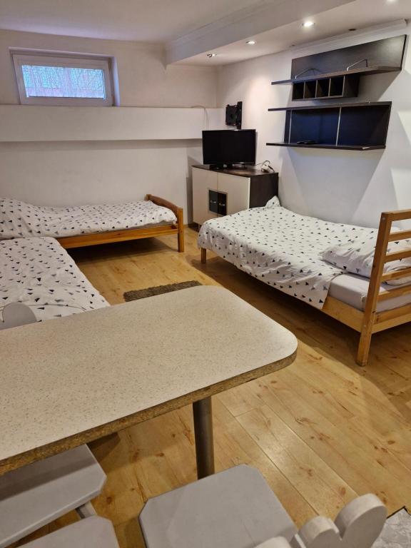 Pokój z 2 łóżkami, stołem i krzesłami w obiekcie Apartament Cichy i Wygodny w mieście Stalowa Wola