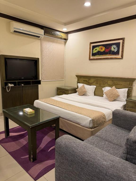 una camera d'albergo con due letti e una TV a schermo piatto di شقق الشعله المخدومه a Riyad