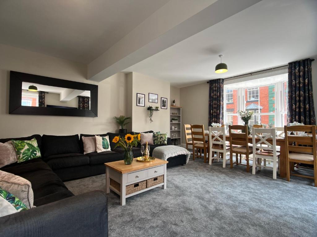 a living room with a couch and a dining room at Llangollen High Street - 4 bedrooms - Sleeps 12 in Llangollen