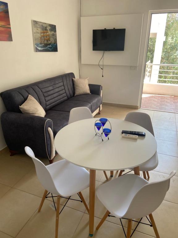 ein Wohnzimmer mit Tisch und Stühlen und einer Couch in der Unterkunft Montebello Inn apartments in Ulcinj