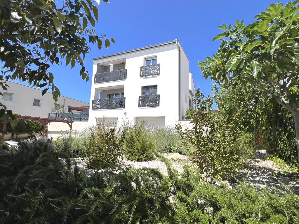 a white building with plants in front of it at Villa Santolina in Maslenica