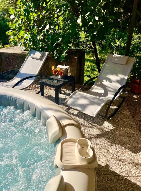 a swimming pool with two chairs and a lazy river at Apartman Bela in Matulji