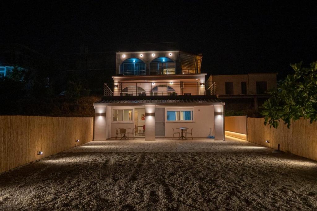 a large house with lights on top of it at night at TSABAS BEACH SIDE APARTMENTS ΤΣΑΜΠΑΣ ΠΑΡΑΛΙΑΚΑ Διαμερίσματα 4 in Kyllini