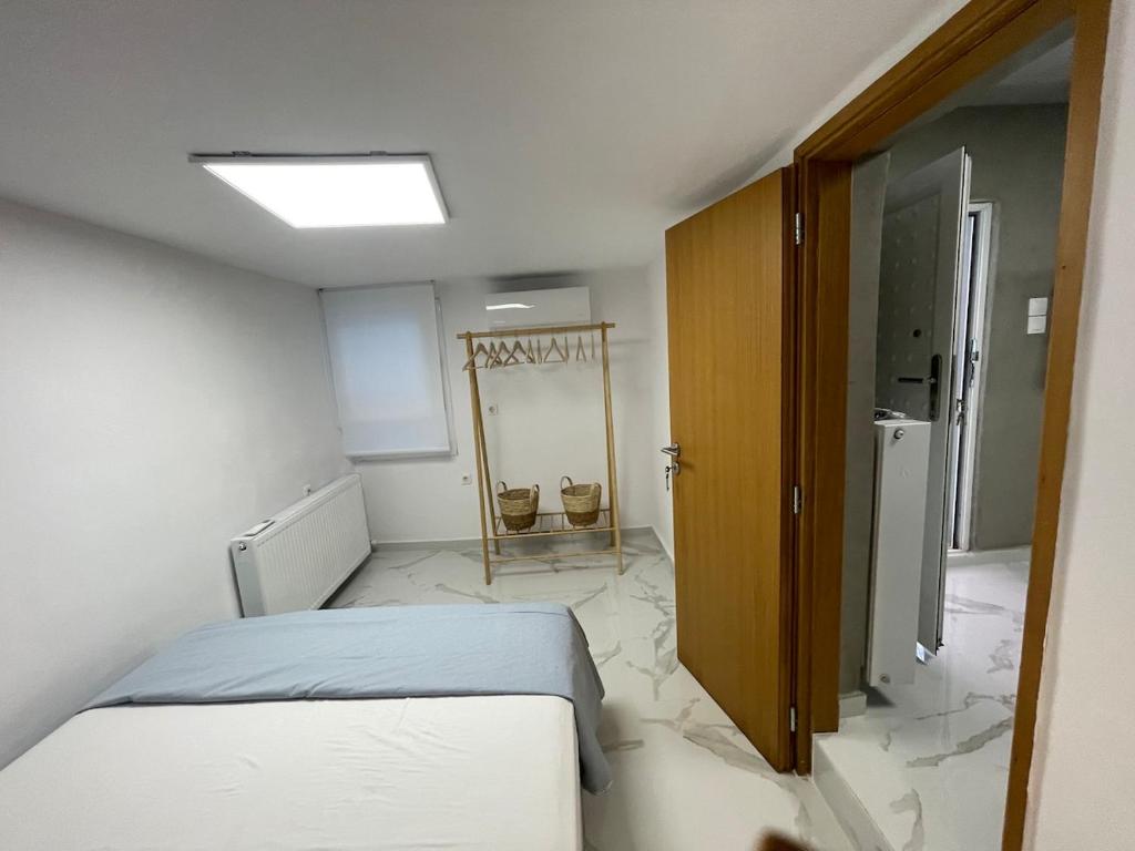 a white room with a bed and a mirror at The Secret Studio - OAKA Stadium & nearby hospitals in Athens