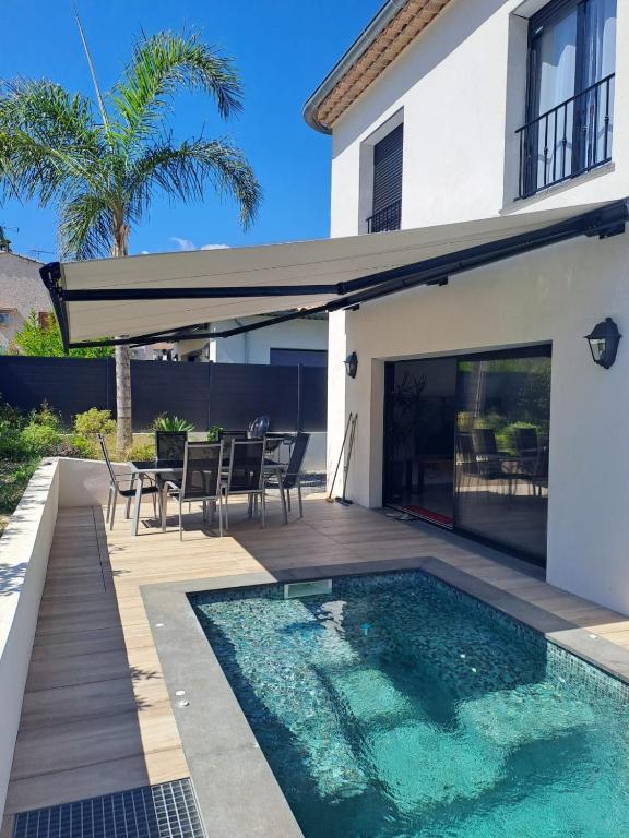 une maison avec une piscine et une terrasse dans l'établissement Villa Piscine-Jacuzzi, à Villeneuve-Loubet