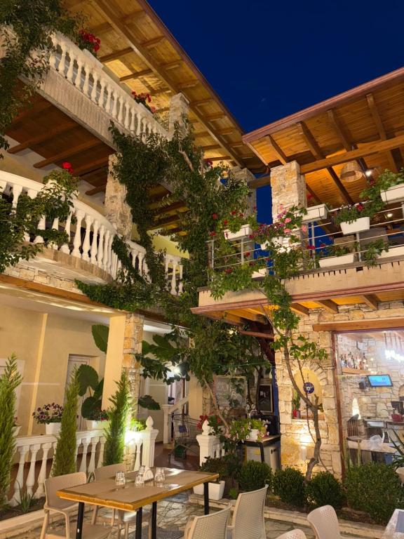 a patio with a table and chairs and plants at Vila Arial in Vlorë