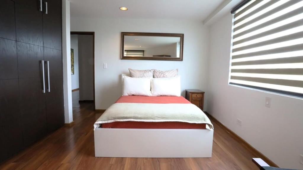 a bedroom with a bed with a mirror on the wall at Park Cimas 3 BR 2 BA Monumental Playas de Tijuana in Tijuana