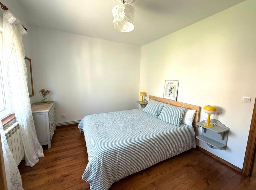 Un dormitorio con una cama en una habitación blanca. en Apartamento a Un Paso de la Playa de Tapia, en Tapia de Casariego