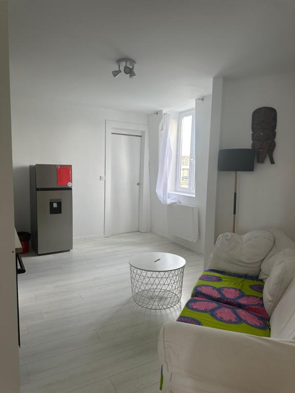 un salon blanc avec un canapé et une table dans l'établissement Nice and warm studio to relax, à Hellemmes-Lille