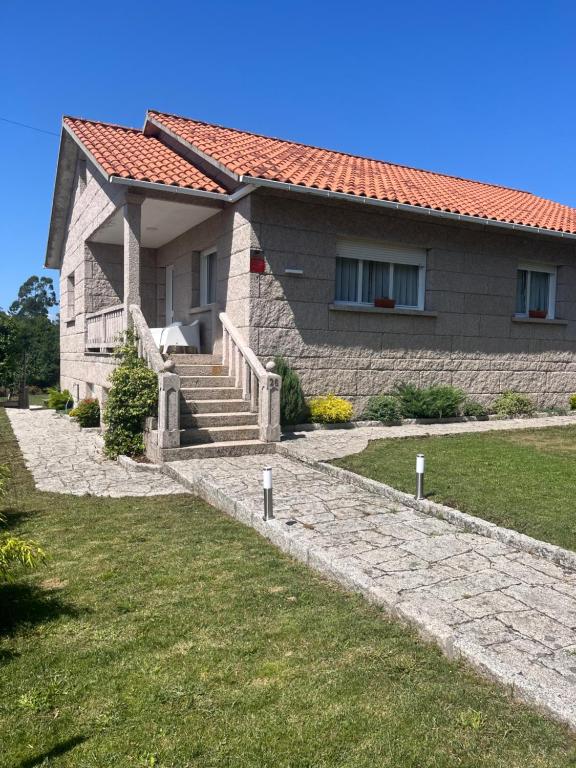 a house with a staircase in front of it at A Casa da bisavoa in Sanxenxo