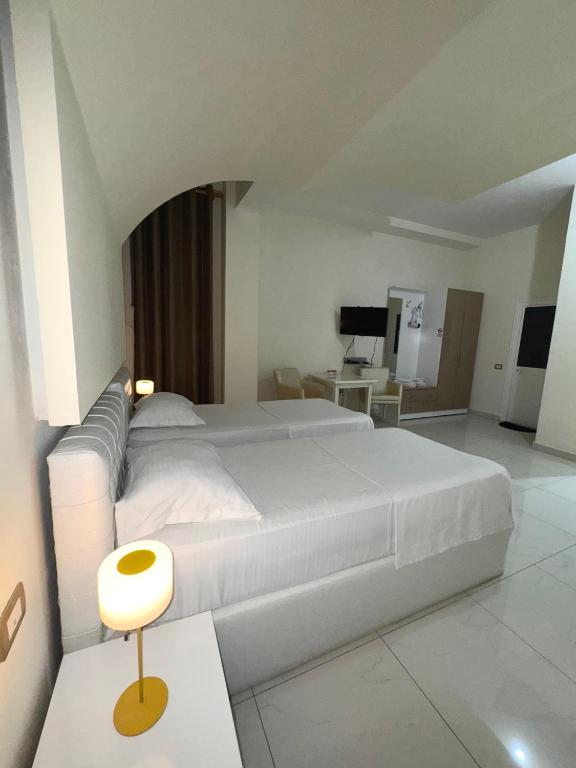 Postel nebo postele na pokoji v ubytování Grand Hotel Gjyshi