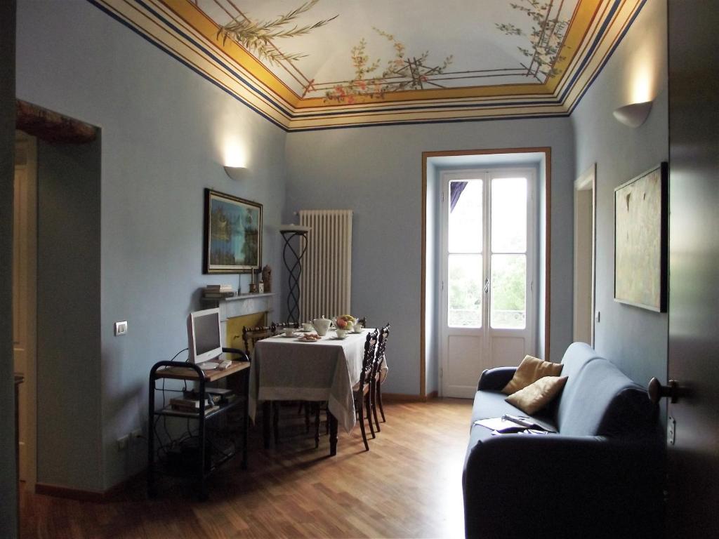 un soggiorno con tavolo e divano di Casa Azzurro Pervinca by Holiday World a Finale Ligure