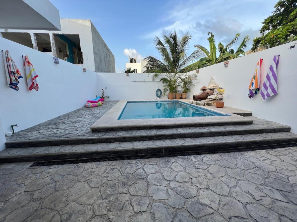 a swimming pool with stairs next to a house at Casa Azul is a tropical oasis in Mahahual