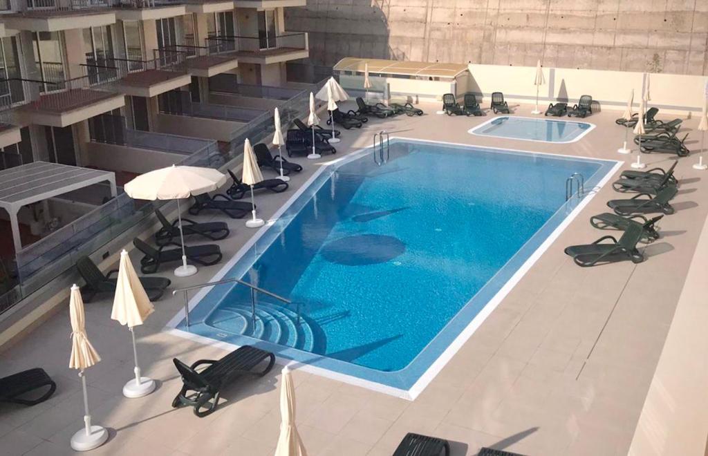an overhead view of a swimming pool with chairs and umbrellas at Poseidon 6 - cozy apartment with swimming pool in Puerto de Santiago