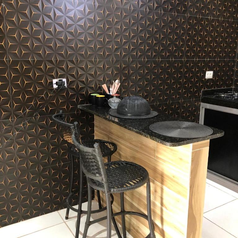 a bar with two chairs and a table in a kitchen at Especial Beira Mar in Maragogi