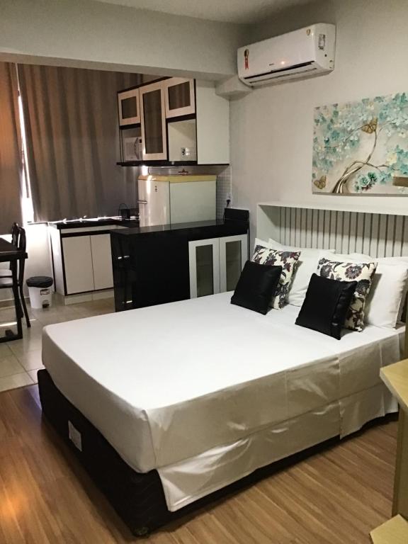 a bedroom with a large white bed in a room at Exelente Apart hotel otima localizaçao in Brasilia