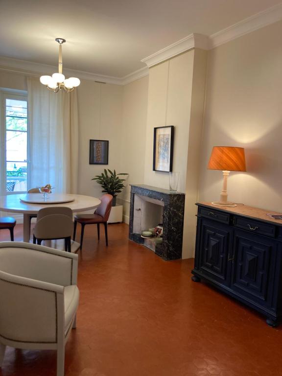 a living room with a table and a fireplace at La Suite Gregoire in Apt